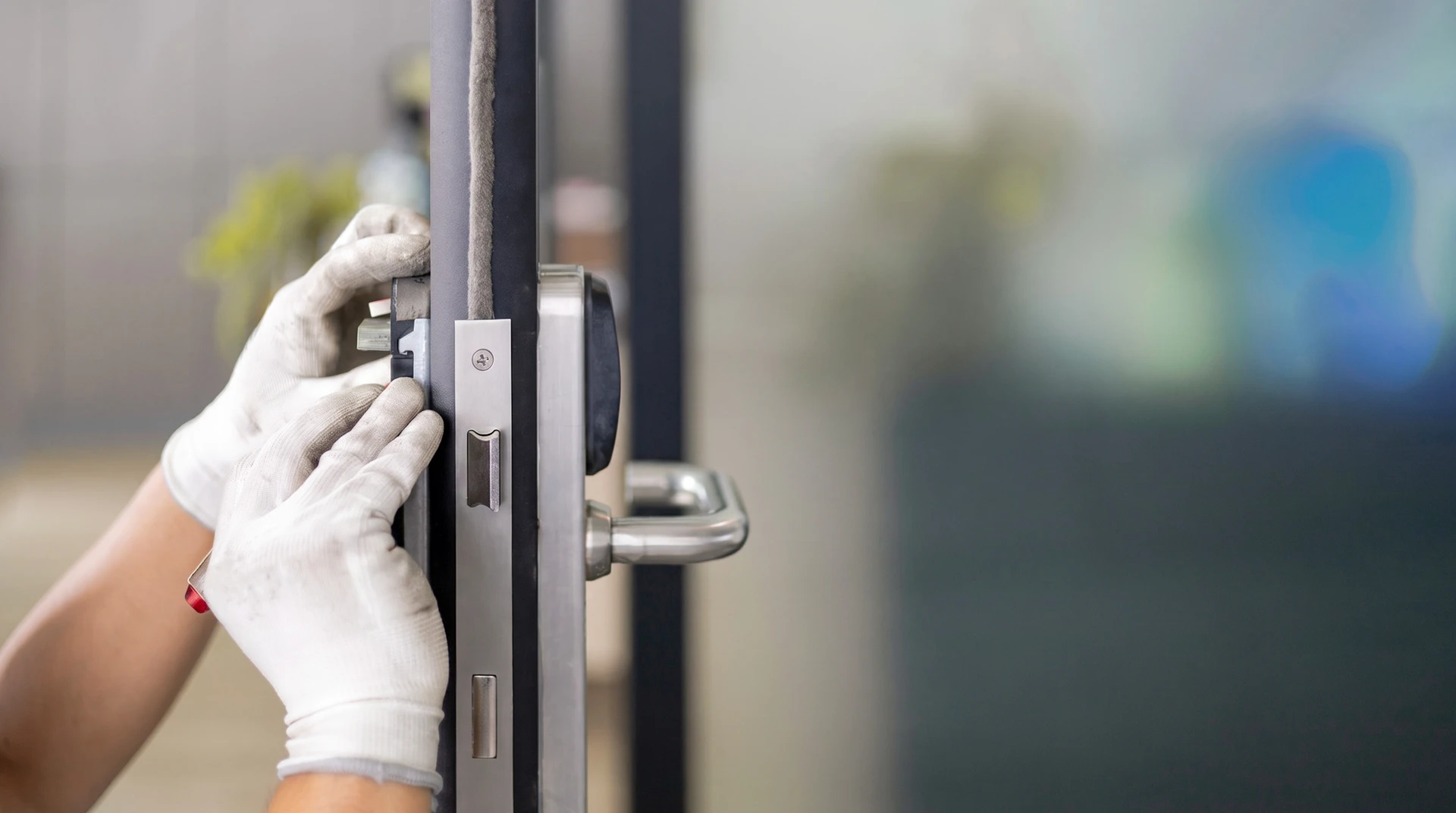 Un serrurier répare une serrure de porte d'entrée en bois vernis
